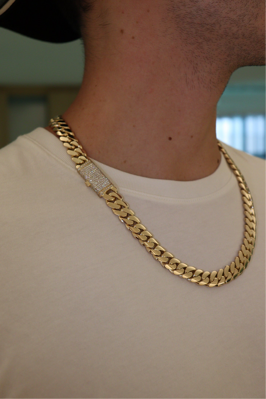 10MM Cuban Link Chain in yellow gold with fully iced-out VVS1 Moissanite Stones Lock, modeled on a 6’1” 180 lbs male wearing a white shirt. Jewelry by SF Jeweler 305.