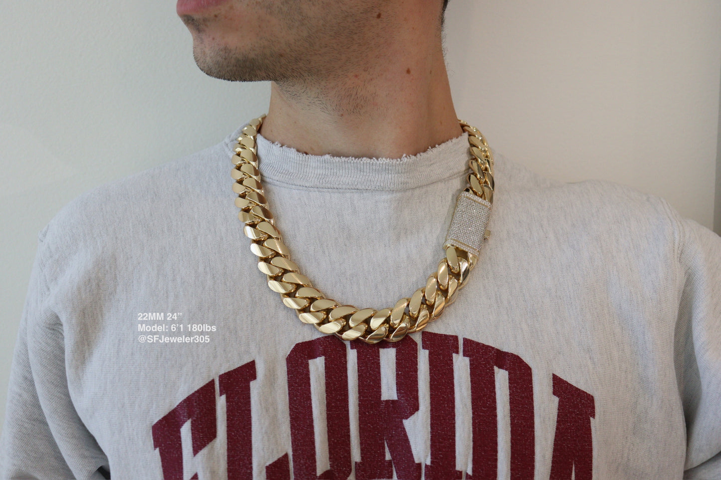 22MM Cuban Link Chain in yellow gold with fully iced-out VVS1 Moissanite Stones Lock, 24-inch length, modeled on a 6’1” 180 lbs male wearing a white shirt. Jewelry by SF Jeweler 305.