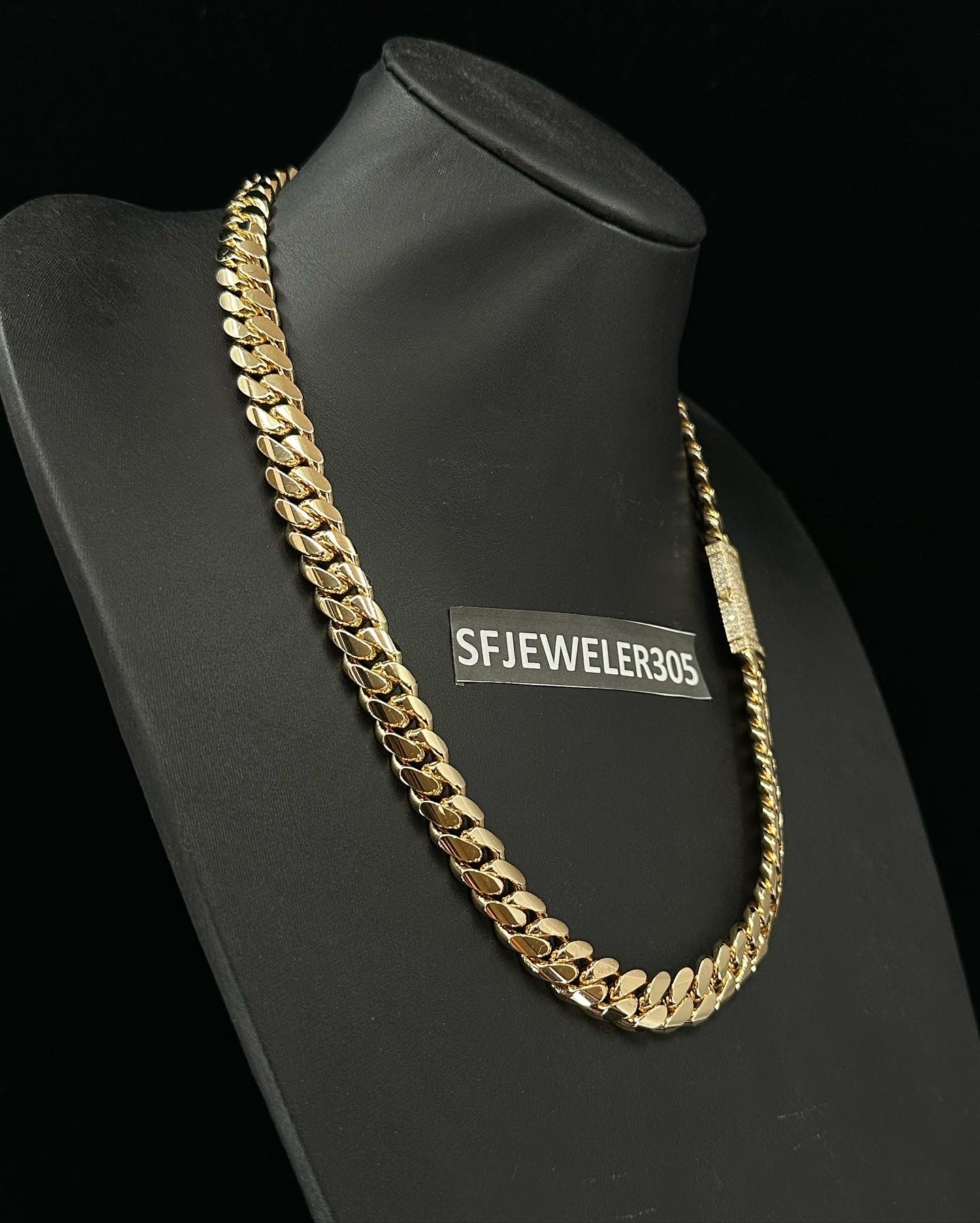 12MM Cuban Link Chain in yellow gold over silver with fully iced-out VVS1 Moissanite Stones Lock, modeled on a 6’1” 180 lbs male wearing a white shirt. Jewelry by SF Jeweler 305.