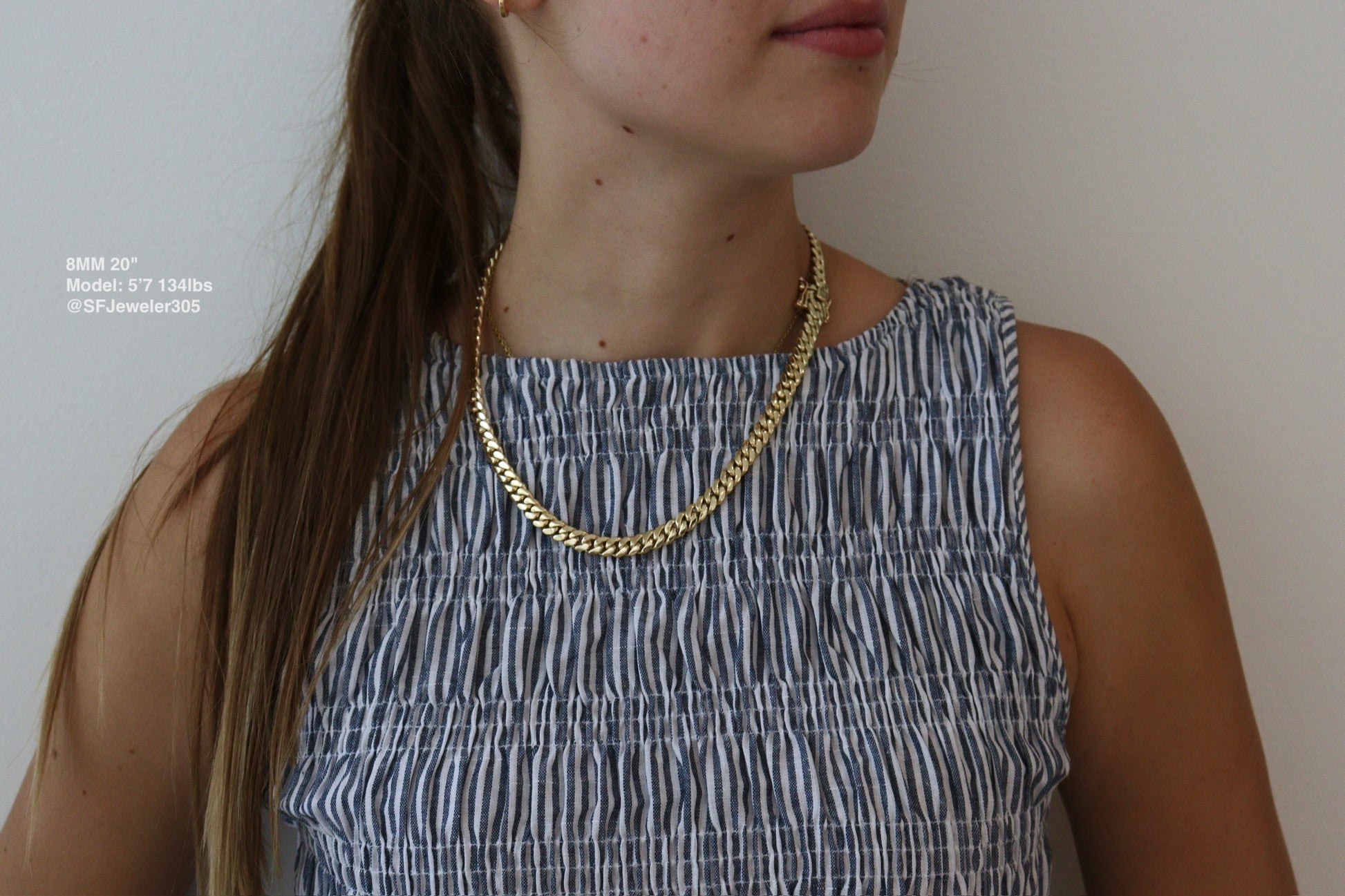 women wearing a 8MM 20-inch yellow gold over silver Cuban link chain, modeled by SF Jeweler 305. The bold Miami Cuban chain has a heavy, polished finish and is styled with a casual t-shirt.