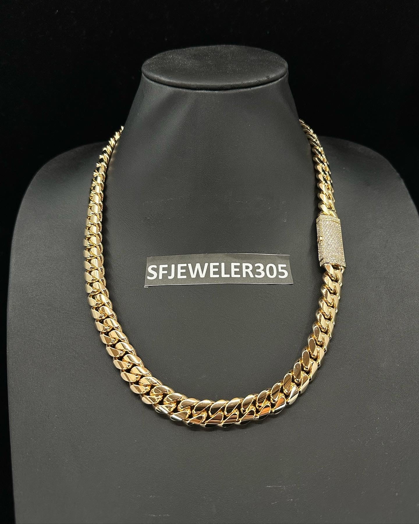 12MM Cuban Link Chain in yellow gold over silver with fully iced-out VVS1 Moissanite Stones Lock, modeled on a 6’1” 180 lbs male wearing a white shirt. Jewelry by SF Jeweler 305.