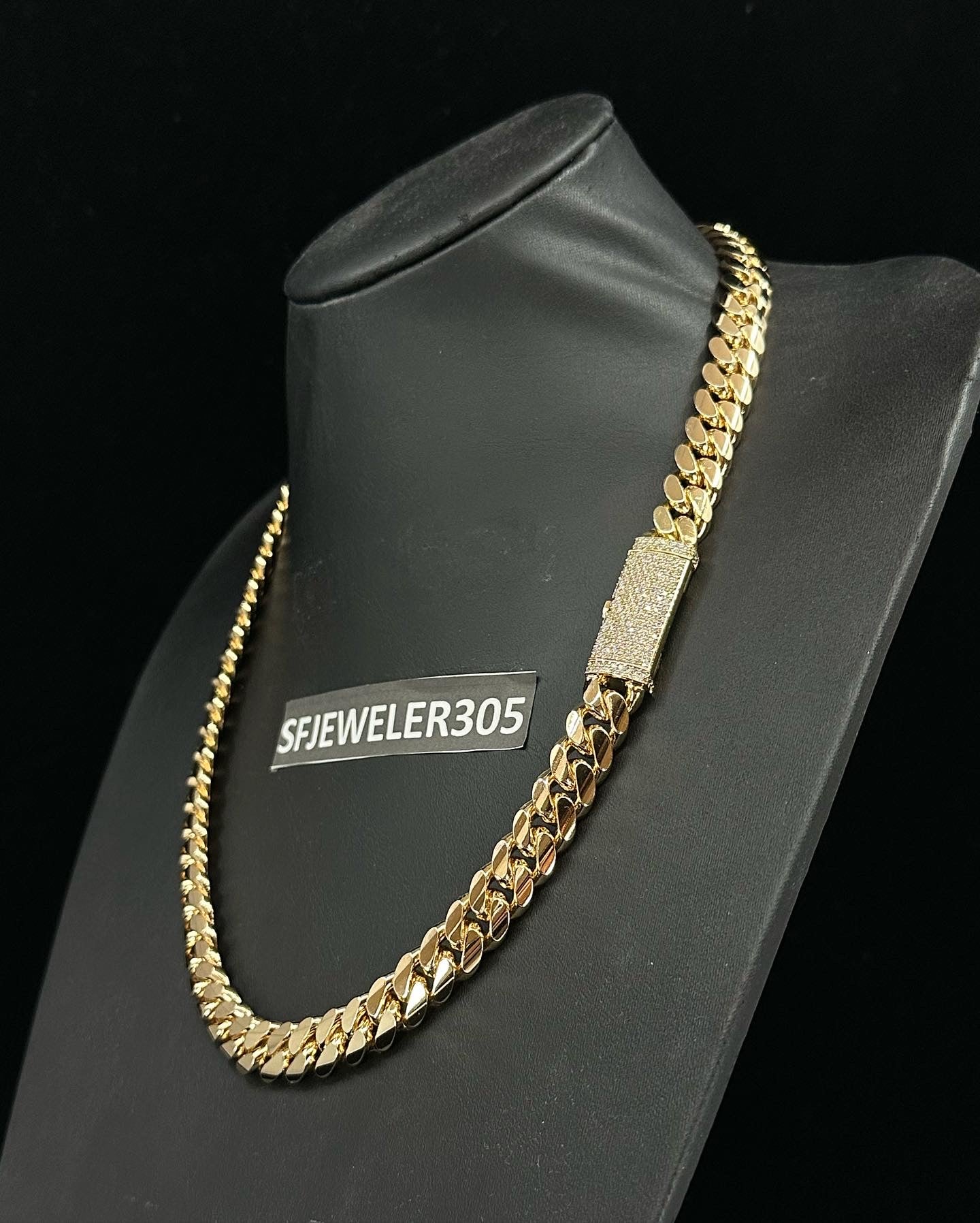 12MM Cuban Link Chain in yellow gold over silver with fully iced-out VVS1 Moissanite Stones Lock, modeled on a 6’1” 180 lbs male wearing a white shirt. Jewelry by SF Jeweler 305.