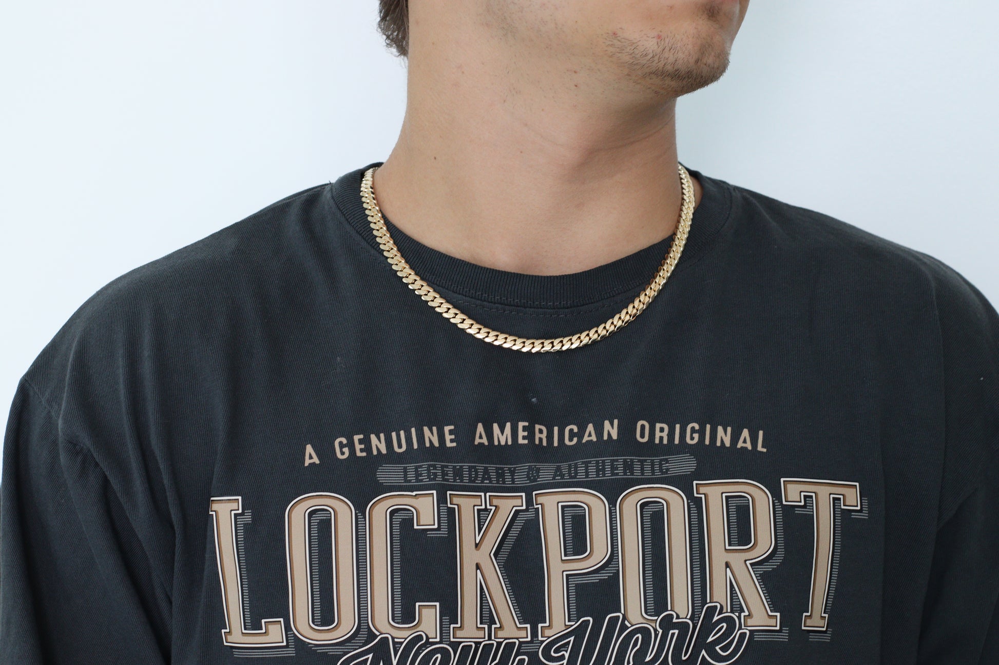 Man wearing a 8MM  yellow gold over silver Cuban link chain, modeled by SF Jeweler 305. The bold Miami Cuban chain has a heavy, polished finish and is styled with a casual t-shirt.