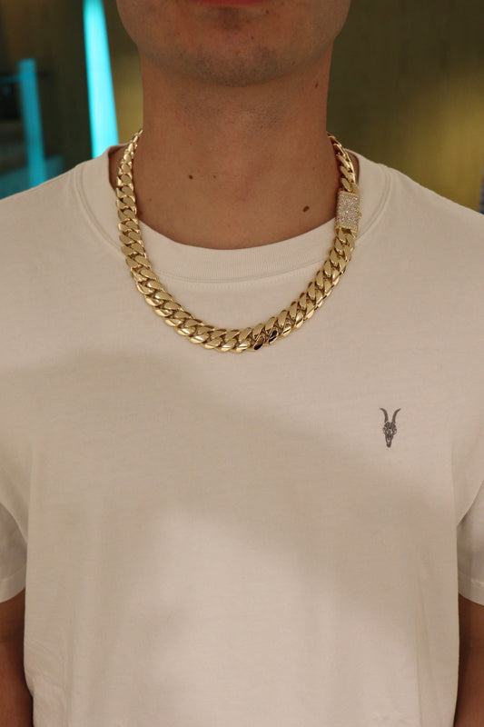 16MM Cuban Link Chain in yellow gold over silver with fully iced-out VVS1 Moissanite Stones Lock, modeled on a 6’1” 180 lbs male wearing a white shirt. Jewelry by SF Jeweler 305.