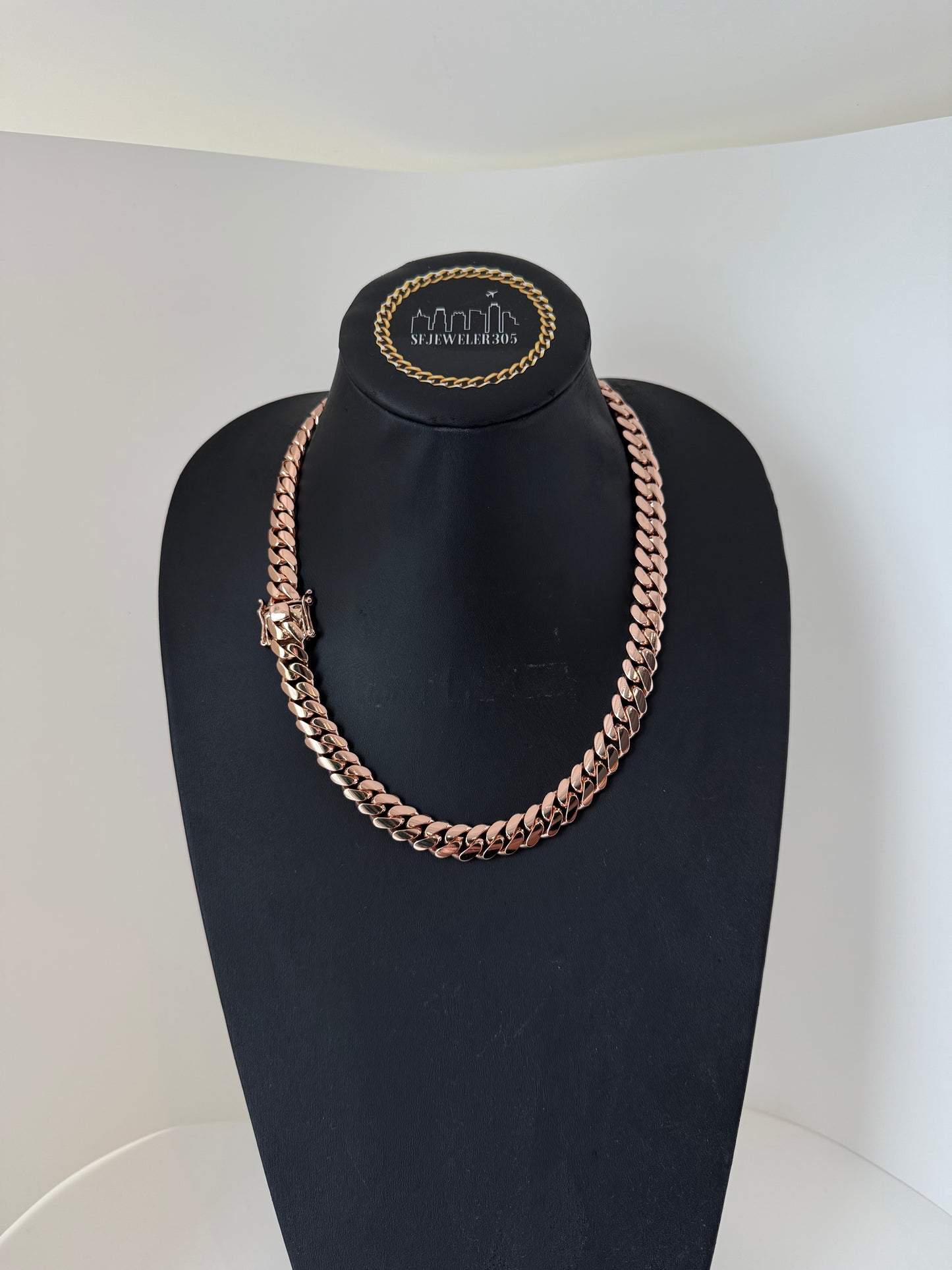 Man wearing a 12MM rose gold over silver Cuban link chain, modeled by SF Jeweler 305. The bold Miami Cuban chain has a heavy, polished finish and is styled with a casual t-shirt.