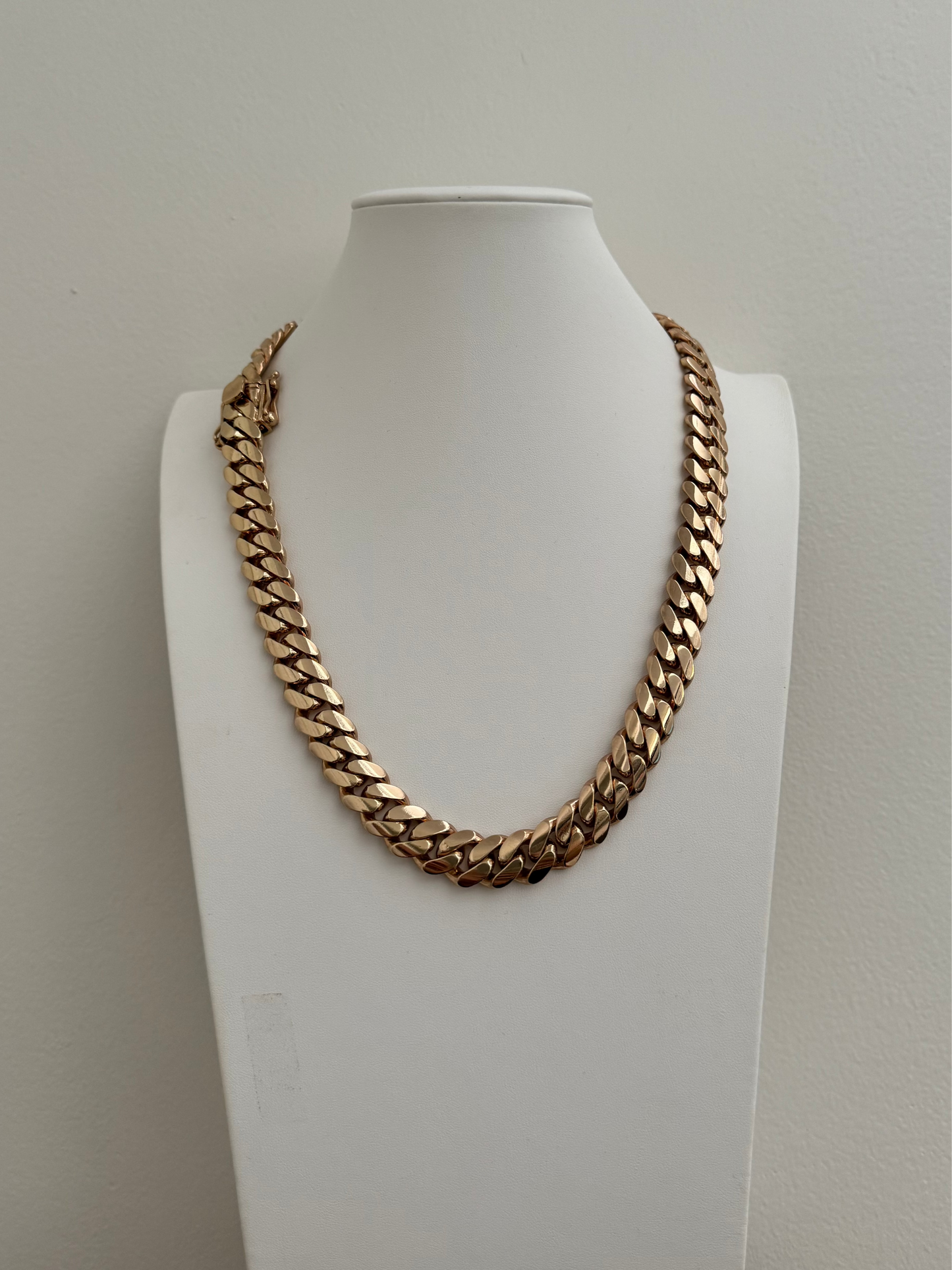 Man wearing a 14MM yellow gold over silver Cuban link chain, modeled by SF Jeweler 305. The bold Miami Cuban chain has a heavy, polished finish and is styled with a casual t-shirt.