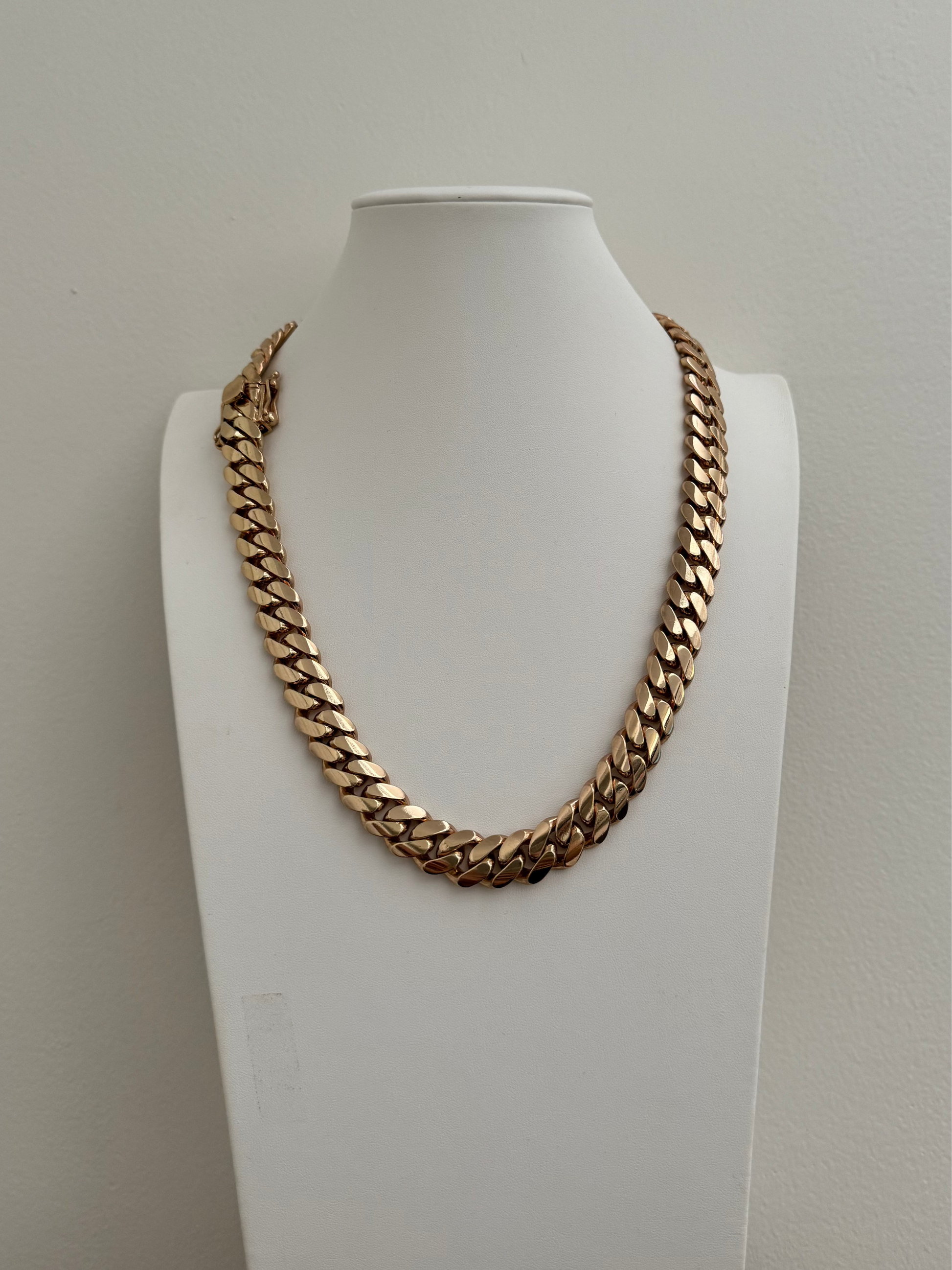 Man wearing a 14MM yellow gold over silver Cuban link chain, modeled by SF Jeweler 305. The bold Miami Cuban chain has a heavy, polished finish and is styled with a casual t-shirt.