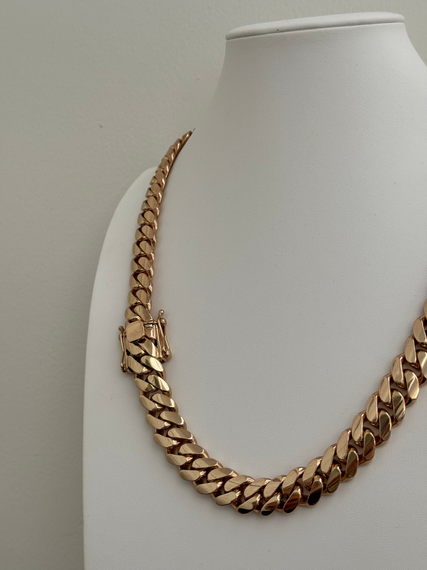 Man wearing a 14MM yellow gold over silver Cuban link chain, modeled by SF Jeweler 305. The bold Miami Cuban chain has a heavy, polished finish and is styled with a casual t-shirt.