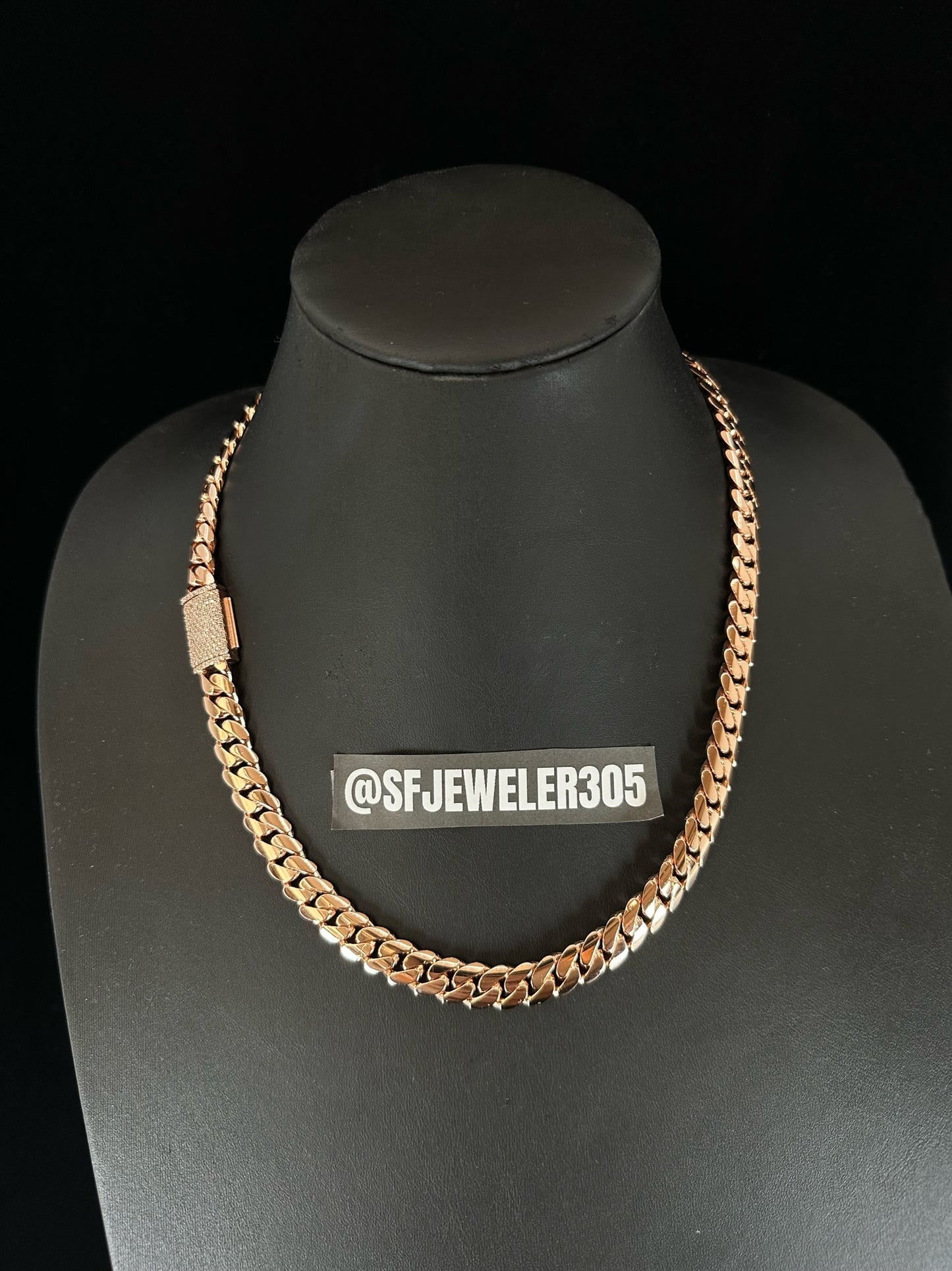 A 10MM rose gold Cuban link chain necklace with a moissanite lock, displayed on a mannequin bust.