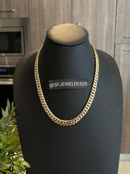 Man wearing a 10MM yellow gold over silver Cuban link chain, modeled by SF Jeweler 305. The bold Miami Cuban chain has a heavy, polished finish and is styled with a casual t-shirt.