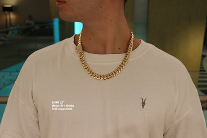 12MM Cuban Link Chain in yellow gold with fully iced-out VVS1 Moissanite Stones Lock, 22-inch length, modeled on a 6’1” 180 lbs male wearing a white shirt. Jewelry by SF Jeweler 305.