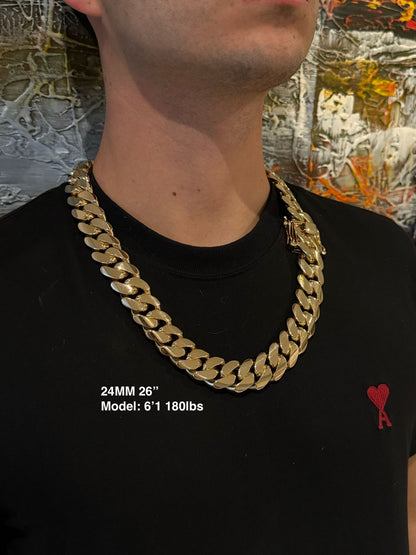 Man wearing a 24MM 26-inch Yellow gold over silver Cuban link chain, modeled by SF Jeweler 305. The bold Miami Cuban chain has a heavy, polished finish and is styled with a casual t-shirt.