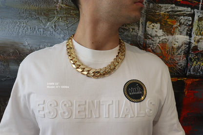 Man wearing a 24MM 22-inch Yellow gold over silver Cuban link chain, modeled by SF Jeweler 305. The bold Miami Cuban chain has a heavy, polished finish and is styled with a casual t-shirt.