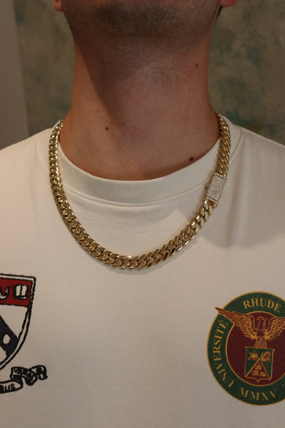 12MM Cuban Link Chain in yellow gold with fully iced-out VVS1 Moissanite Stones Lock, modeled on a 6’1” 180 lbs male wearing a white shirt. Jewelry by SF Jeweler 305.