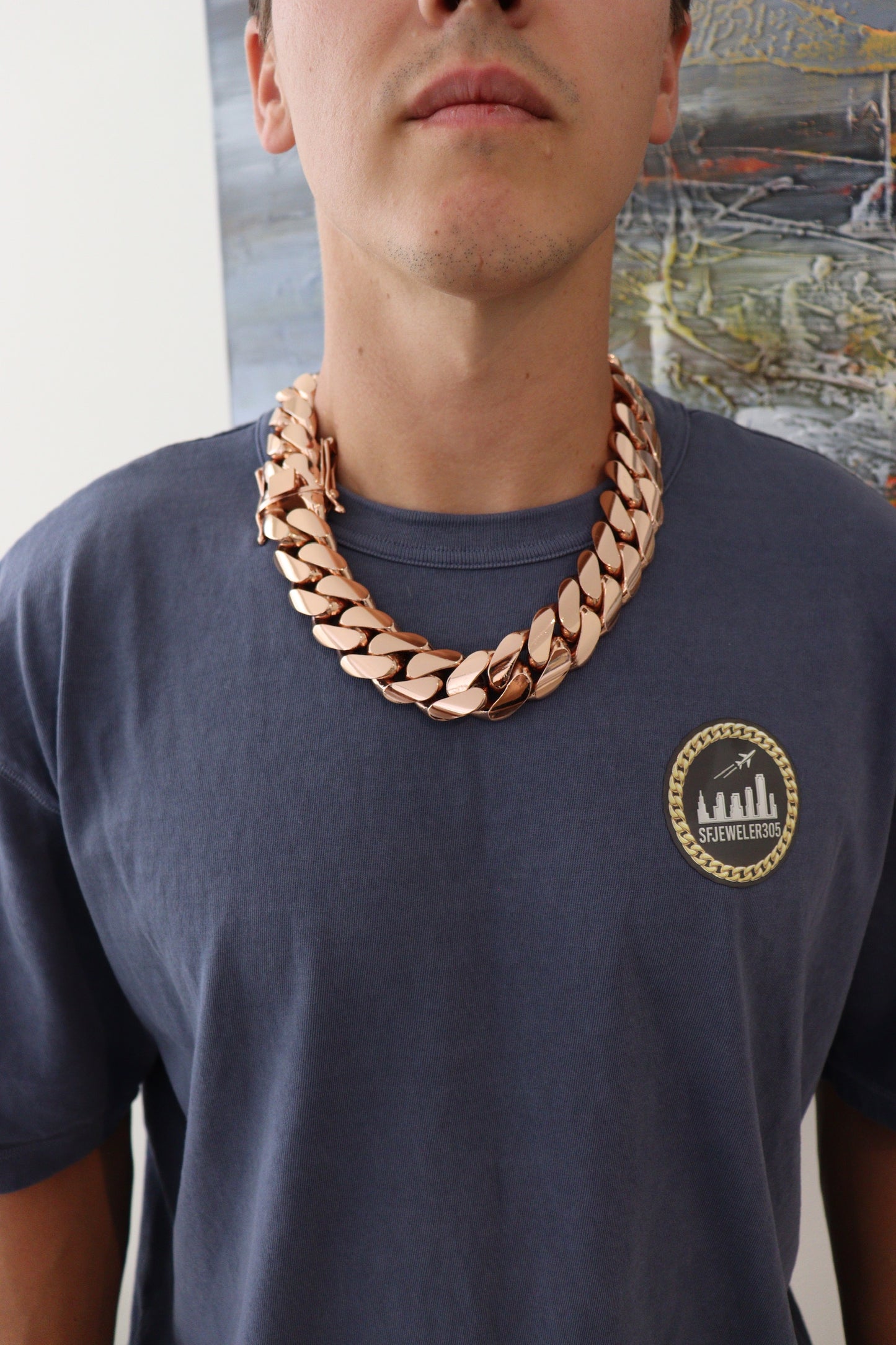 Man wearing a 30MM 22-inch rose gold over silver Cuban link chain, modeled by SF Jeweler 305. The bold Miami Cuban chain has a heavy, polished finish and is styled with a casual t-shirt.