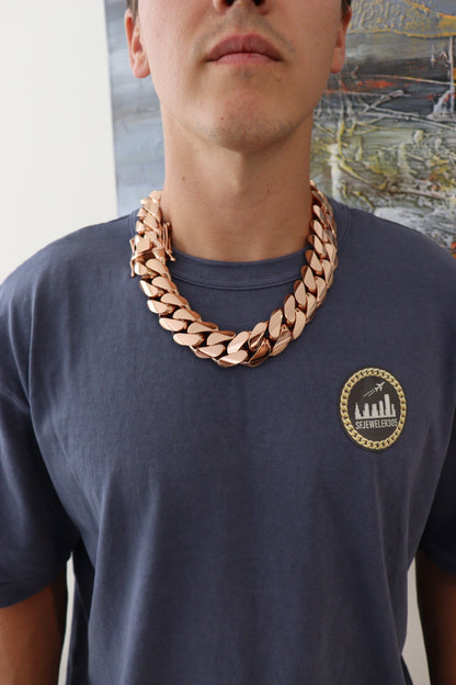 Man wearing a 30MM 22-inch rose gold over silver Cuban link chain, modeled by SF Jeweler 305. The bold Miami Cuban chain has a heavy, polished finish and is styled with a casual t-shirt.