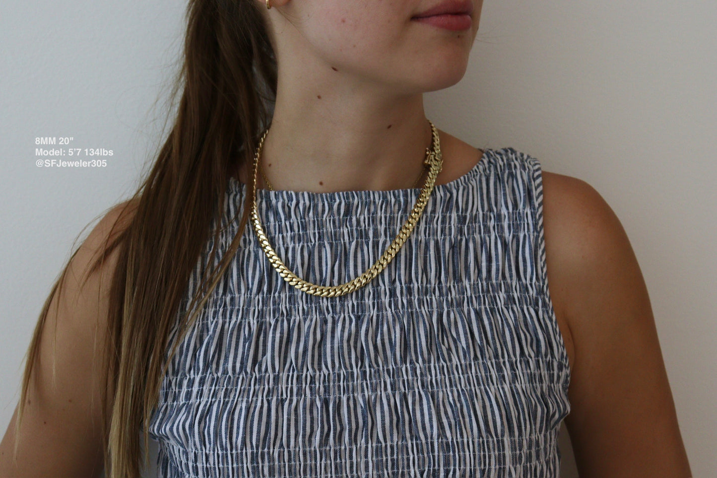 women wearing a 8MM 20-inch yellow gold over silver Cuban link chain, modeled by SF Jeweler 305. The bold Miami Cuban chain has a heavy, polished finish and is styled with a casual t-shirt.