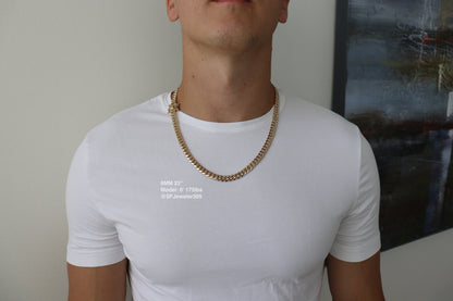 Man wearing a 8MM 22-inch yellow gold over silver Cuban link chain, modeled by SF Jeweler 305. The bold Miami Cuban chain has a heavy, polished finish and is styled with a casual t-shirt.