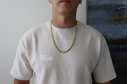 Man wearing a 8MM 24-inch yellow gold over silver Cuban link chain, modeled by SF Jeweler 305. The bold Miami Cuban chain has a heavy, polished finish and is styled with a casual t-shirt.