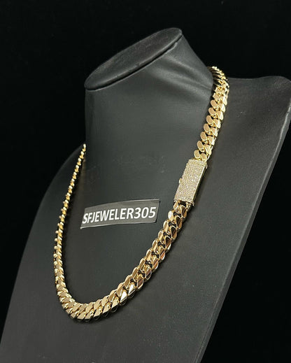 12MM Cuban Link Chain in yellow gold over silver with fully iced-out VVS1 Moissanite Stones Lock, modeled on a 6’1” 180 lbs male wearing a white shirt. Jewelry by SF Jeweler 305.