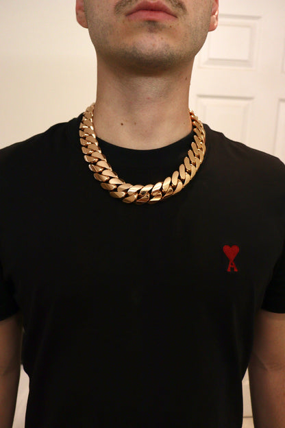 Man wearing a 24MM rose gold over silver Cuban link chain, modeled by SF Jeweler 305. The bold Miami Cuban chain has a heavy, polished finish and is styled with a casual t-shirt.