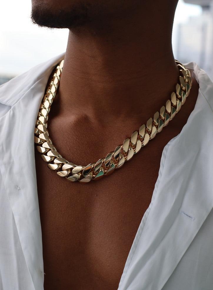 Man wearing a 20MM Yellow gold over silver Cuban link chain, modeled by SF Jeweler 305. The bold Miami Cuban chain has a heavy, polished finish and is styled with a casual t-shirt.