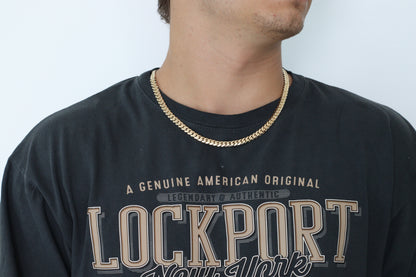 Man wearing a 8MM  yellow gold over silver Cuban link chain, modeled by SF Jeweler 305. The bold Miami Cuban chain has a heavy, polished finish and is styled with a casual t-shirt.