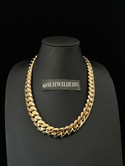 Man wearing a 18MM Yellow gold over silver Cuban link chain, modeled by SF Jeweler 305. The bold Miami Cuban chain has a heavy, polished finish and is styled with a casual t-shirt.