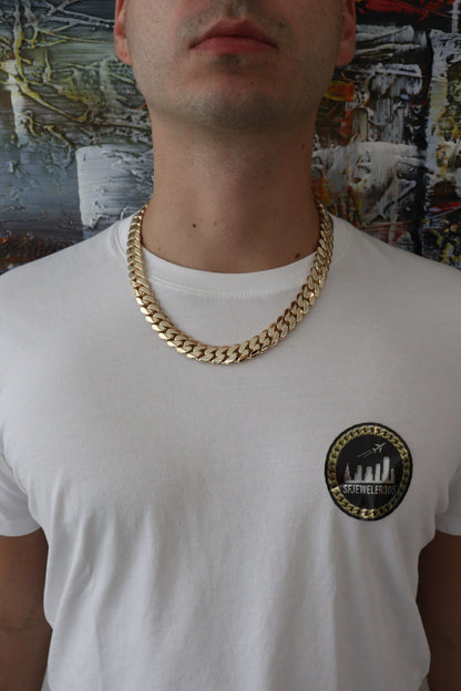 Man wearing a 14MM yellow gold over silver Cuban link chain, modeled by SF Jeweler 305. The bold Miami Cuban chain has a heavy, polished finish and is styled with a casual t-shirt.