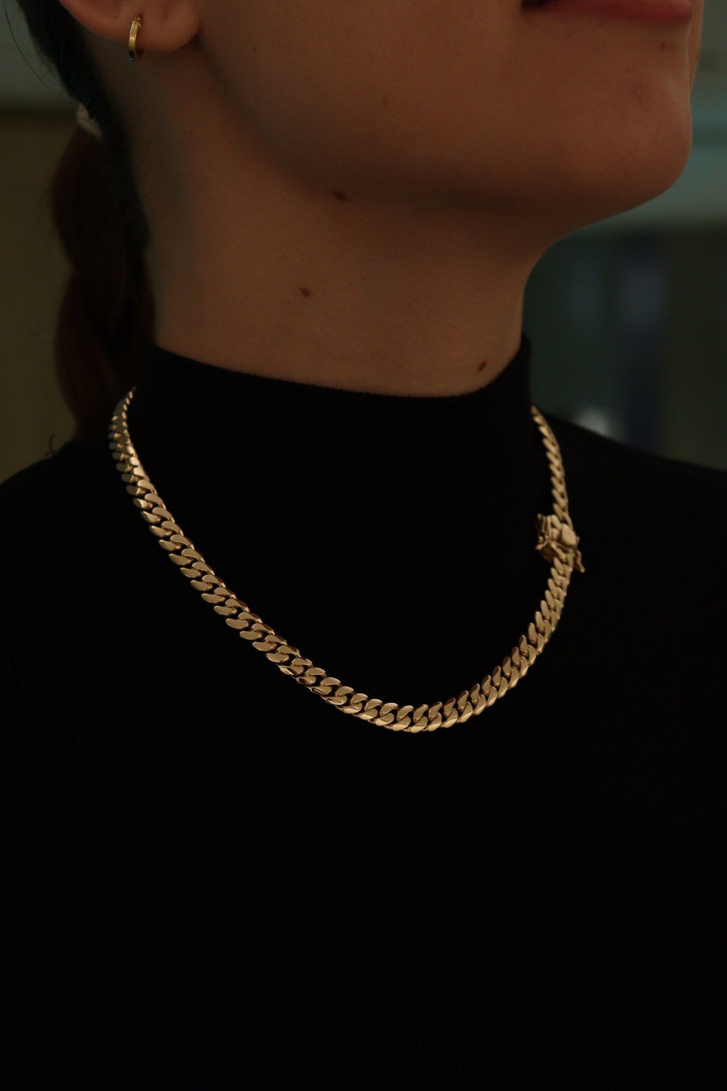 women wearing a 8MM yellow gold over silver Cuban link chain, modeled by SF Jeweler 305. The bold Miami Cuban chain has a heavy, polished finish and is styled with a casual t-shirt.