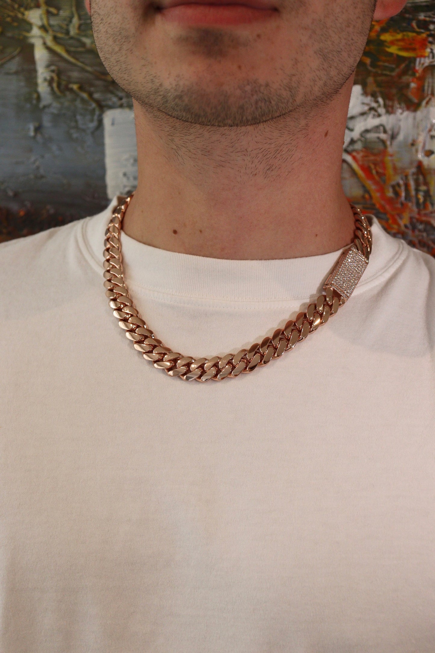 14MM Cuban Link Chain in rose gold over silver with fully iced-out VVS1 Moissanite Stones Lock, modeled on a 6’1” 180 lbs male wearing a white shirt. Jewelry by SF Jeweler 305.
