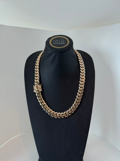 A 16MM Cuban Link Chain necklace made of silver with yellow gold plating, displayed on a mannequin bust.