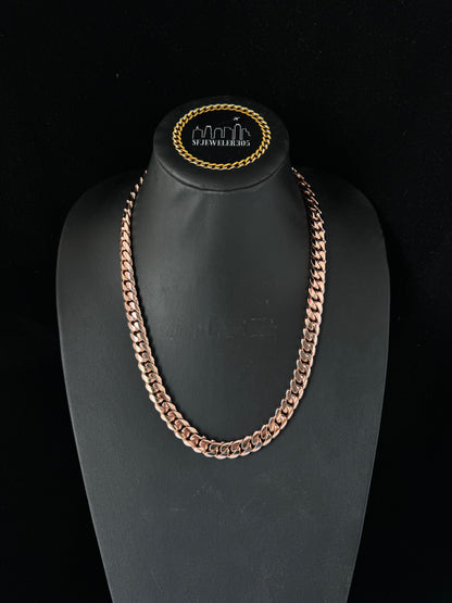 Man wearing a 10MM rose gold over silver Cuban link chain, modeled by SF Jeweler 305. The bold Miami Cuban chain has a heavy, polished finish and is styled with a casual t-shirt.