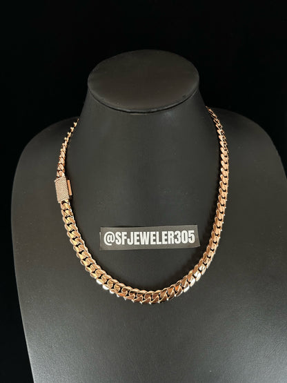 A 10MM rose gold Cuban link chain necklace with a moissanite lock, displayed on a mannequin bust.